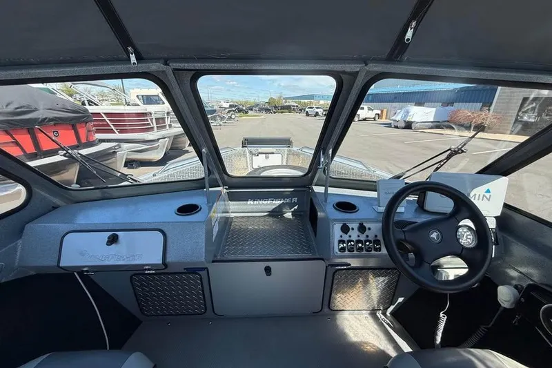 Slide: The Image of Interior view of 2021 KingFisher 1625 Falcon boat cockpit with steering wheel and controls. - 12