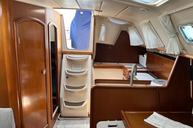 Slide: The Image of Interior of a 1999 Beneteau Oceanis 321 sailboat, featuring wood finishes and compact design. - 12