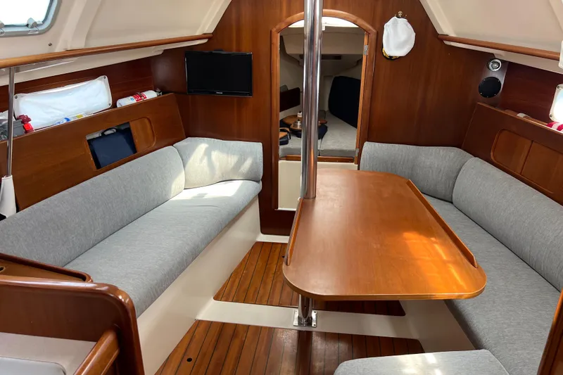 Slide: The Image of Interior of 1999 Beneteau Oceanis 321 sailboat with cozy seating and wooden table. - 13