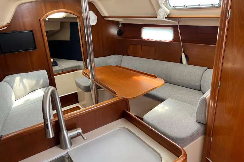 Slide: The Image of Interior of 1999 Beneteau Oceanis 321 sailboat with cozy seating and wooden finishes. - 14