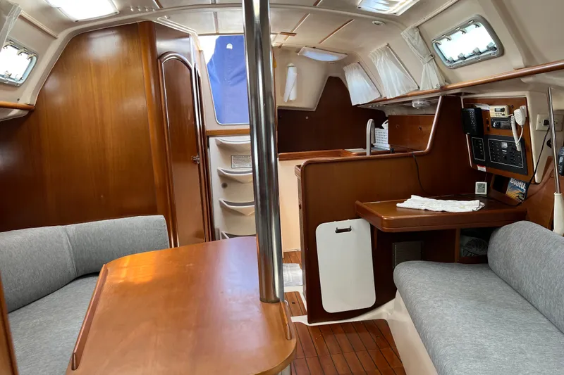 Slide: The Image of Interior of 1999 Beneteau Oceanis 321 sailboat with wood finish and seating area. - 15