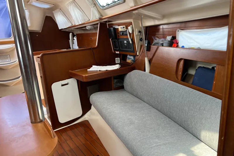 Slide: The Image of Interior of 1999 Beneteau Oceanis 321 sailboat with wooden finish and cozy seating area. - 16