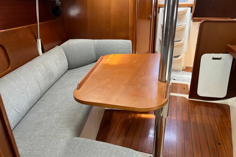 Slide: The Image of Interior of 1999 Beneteau Oceanis 321 sailboat with wooden table and gray seating. - 17