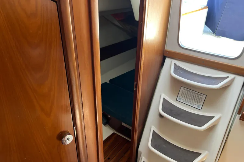 Slide: The Image of Interior view of 1999 Beneteau Oceanis 321 sailboat, featuring wooden door and cabin steps. - 18