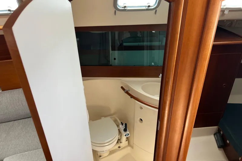 Slide: The Image of Interior view of 1999 Beneteau Oceanis 321 sailboat bathroom with wooden accents. - 24