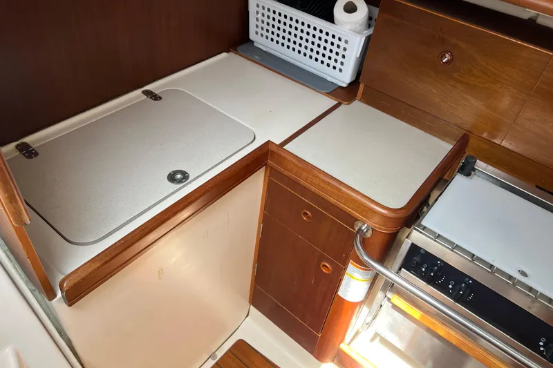 Slide: The Image of Galley kitchen in 1999 Beneteau Oceanis 321 sailboat with wooden cabinetry and stove. - 25