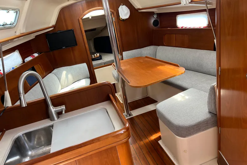 Slide: The Image of Interior of 1999 Beneteau Oceanis 321 sailboat with cozy seating and wooden finishes. - 27
