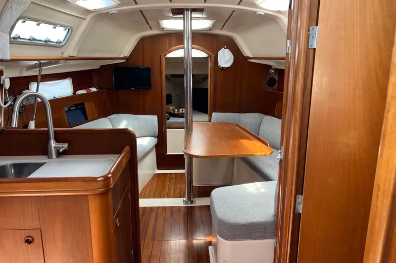 Slide: The Image of Interior of 1999 Beneteau Oceanis 321 sailboat with wood finish and cozy seating area. - 28