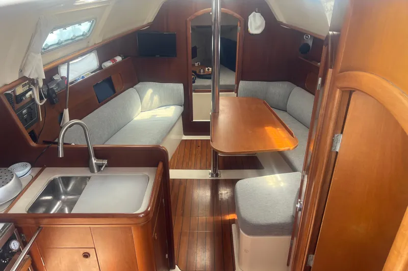 Slide: The Image of Interior of 1999 Beneteau Oceanis 321 sailboat with cozy seating and wooden finishes. - 29