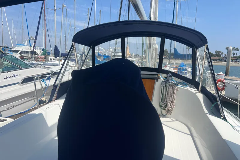 Slide: The Image of 1999 Beneteau Oceanis 321 sailboat docked at marina, featuring cockpit and canopy. - 31