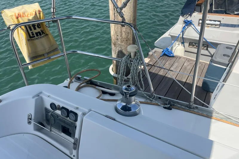 Slide: The Image of Beneteau Oceanis 321 sailboat deck, featuring winch and safety equipment, docked at marina. - 33