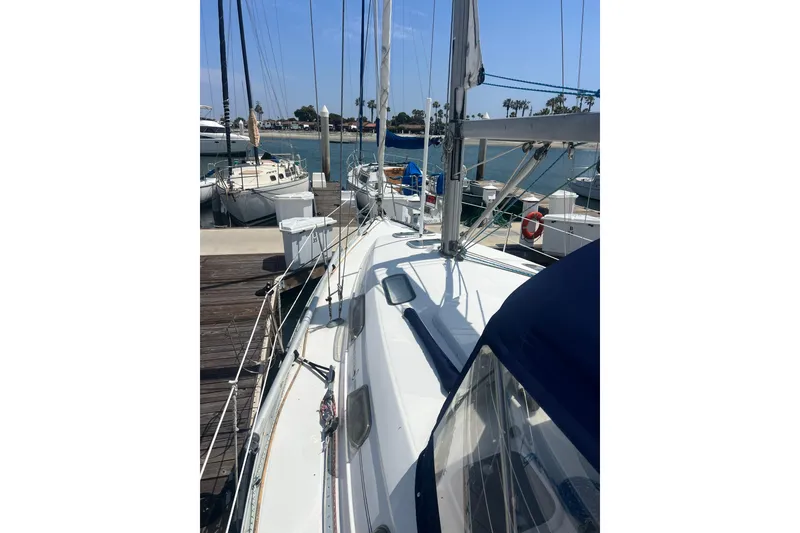 Slide: The Image of 1999 Beneteau Oceanis 321 sailboat docked at marina, clear sky, calm waters. - 38