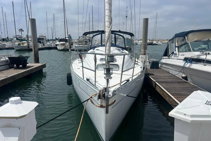Slide: The Image of 1999 Beneteau Oceanis 321 sailboat docked at a marina, surrounded by other boats. - 42