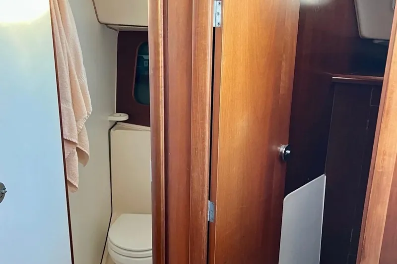 Slide: The Image of Interior view of 1999 Beneteau Oceanis 321 sailboat bathroom with wooden door and towel. - 7