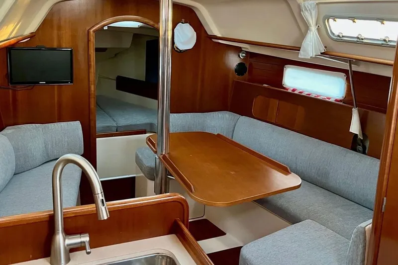 Slide: The Image of Interior of 1999 Beneteau Oceanis 321 sailboat with cozy seating and wooden table. - 8