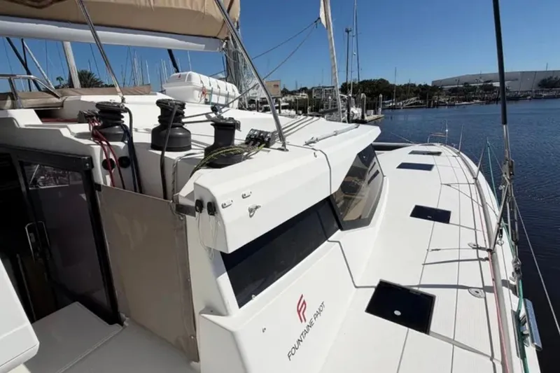 Slide: The Image of 2018 Fountaine Pajot Saona 47 catamaran docked at marina, showcasing sleek design and spacious deck. - 13