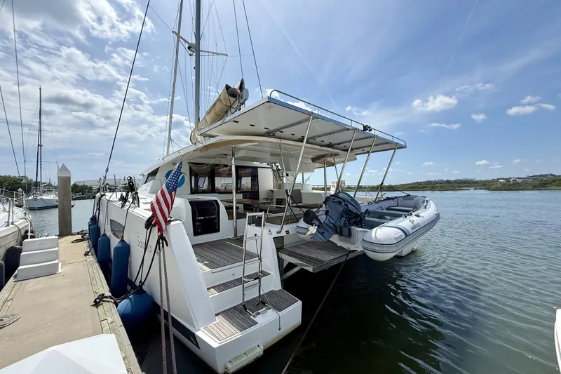 Slide: The Image of 2018 Fountaine Pajot Saona 47 catamaran docked with inflatable boat and American flag. - 17
