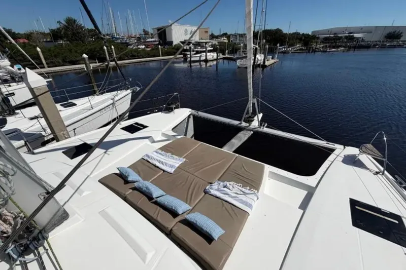 Slide: The Image of 2018 Fountaine Pajot Saona 47 catamaran with sunbathing area, docked at marina. - 2