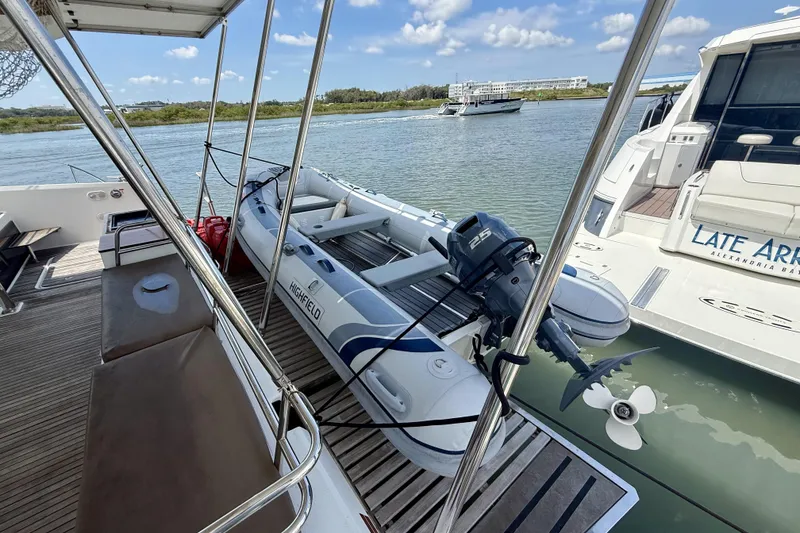 Slide: The Image of 2018 Fountaine Pajot Saona 47 catamaran with inflatable dinghy, docked in a serene marina. - 59