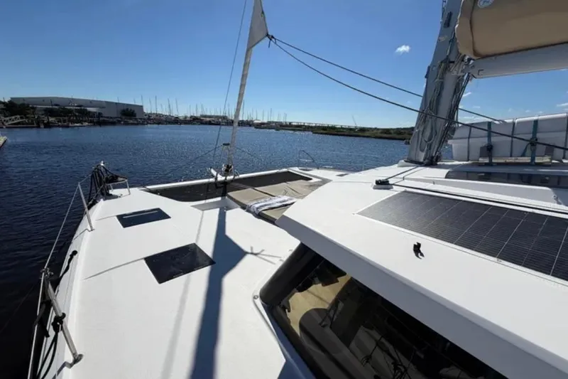 Slide: The Image of 2018 Fountaine Pajot Saona 47 catamaran on calm water, showcasing deck and sails. - 8