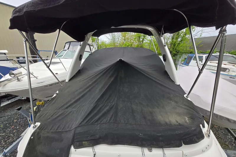 Slide: The Image of 2007 Monterey 270 Cruiser boat with black cover in a marina setting. - 6
