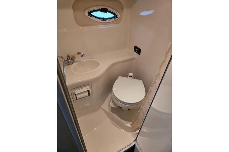 Slide: The Image of Compact bathroom in 2007 Monterey 270 Cruiser with toilet, sink, and porthole window. - 9