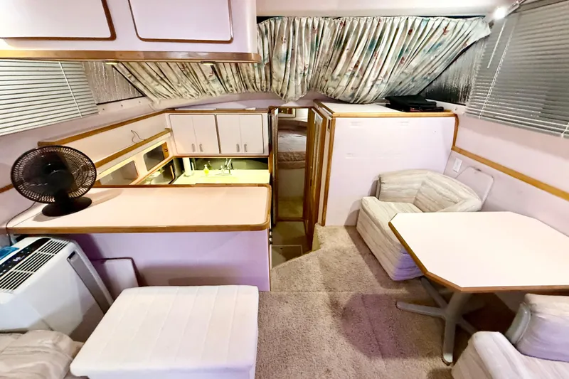 Slide: The Image of 1989 Sea Ray 380 Aft Cabin interior with kitchen, seating area, and cozy decor. - 11