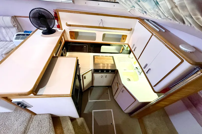 Slide: The Image of 1989 Sea Ray 380 Aft Cabin kitchen with modern appliances and compact design. - 13