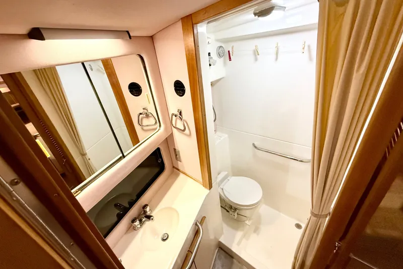 Slide: The Image of 1989 Sea Ray 380 Aft Cabin bathroom with sink, mirror, and toilet. - 16