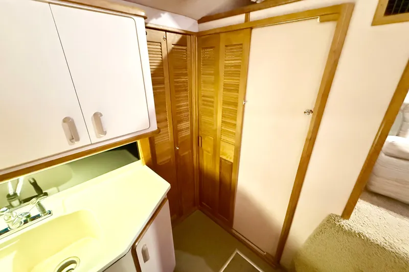 Slide: The Image of Interior of 1989 Sea Ray 380 Aft Cabin with sink and wooden cabinets. - 17