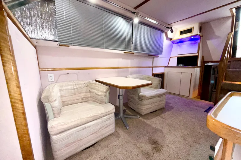 Slide: The Image of Interior of 1989 Sea Ray 380 Aft Cabin with cozy seating and dining area. - 18