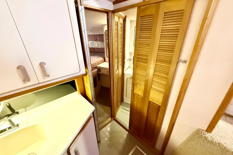 Slide: The Image of 1989 Sea Ray 380 Aft Cabin interior with wooden cabinetry and cozy sleeping area. - 20
