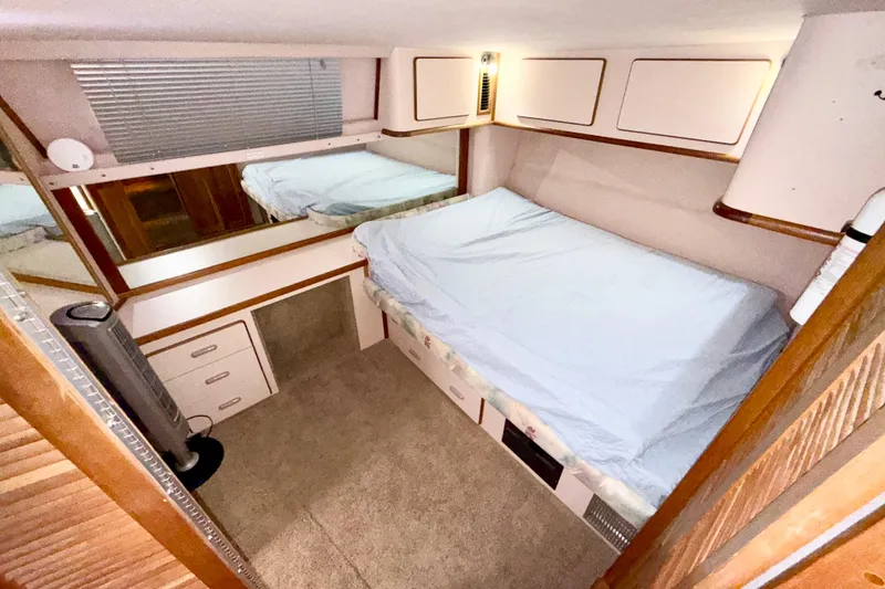Slide: The Image of 1989 Sea Ray 380 Aft Cabin interior with bed, storage, and mirror. - 22