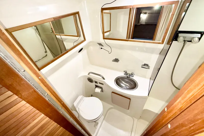 Slide: The Image of 1989 Sea Ray 380 Aft Cabin bathroom with sink, toilet, and mirror. - 23