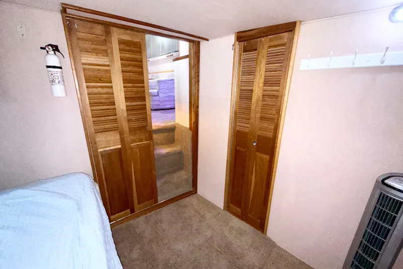 Slide: The Image of 1989 Sea Ray 380 Aft Cabin interior with wooden doors and cozy carpeted flooring. - 26