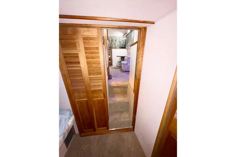 Slide: The Image of Interior view of 1989 Sea Ray 380 Aft Cabin with wooden closet and carpeted floor. - 27