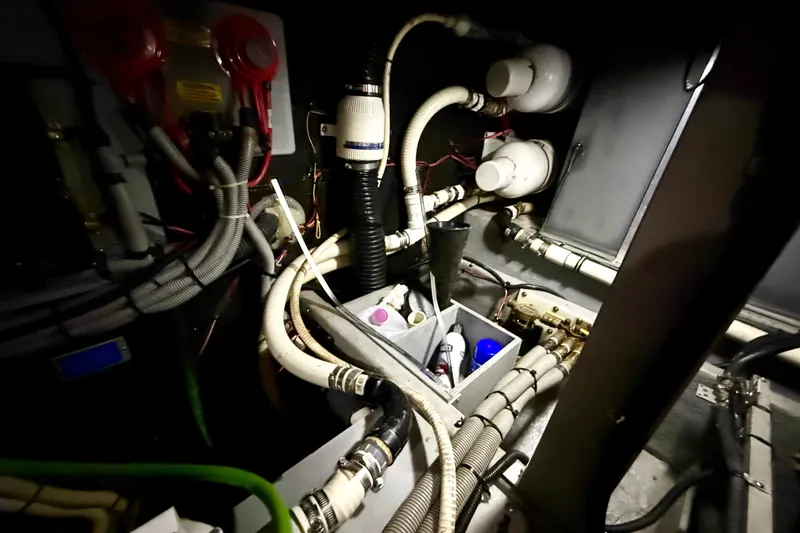 Slide: The Image of Engine room of 1989 Sea Ray 380 Aft Cabin with hoses and mechanical components. - 29