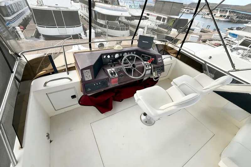 Slide: The Image of 1989 Sea Ray 380 Aft Cabin helm with dual seats, overlooking marina. - 4
