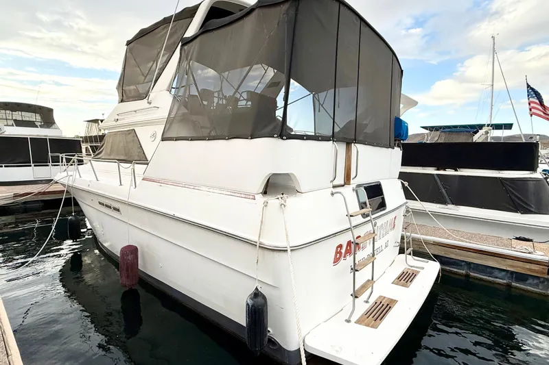 Slide: The Image of 1989 Sea Ray 380 Aft Cabin yacht docked at marina with American flag. - 41