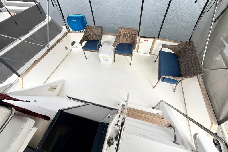 Slide: The Image of 1989 Sea Ray 380 Aft Cabin boat deck with wicker chairs and cooler. - 6