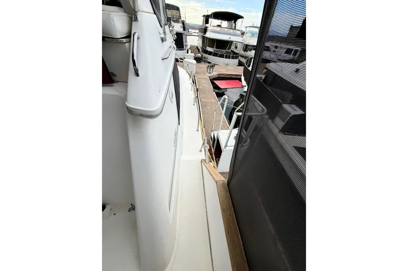 Slide: The Image of 1989 Sea Ray 380 Aft Cabin yacht docked, showcasing side deck and marina view. - 7