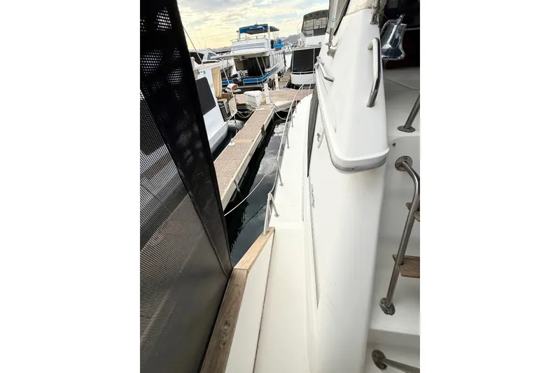 Slide: The Image of 1989 Sea Ray 380 Aft Cabin yacht docked, showcasing side deck and marina view. - 8