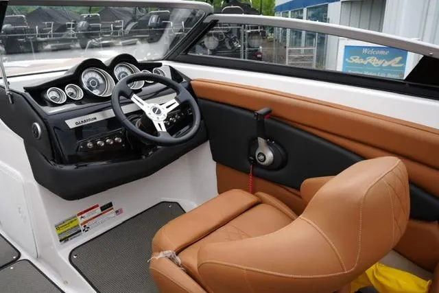 Slide: The Image of 2017 Glastron GT 245 boat interior with tan seating and modern dashboard controls. - 12