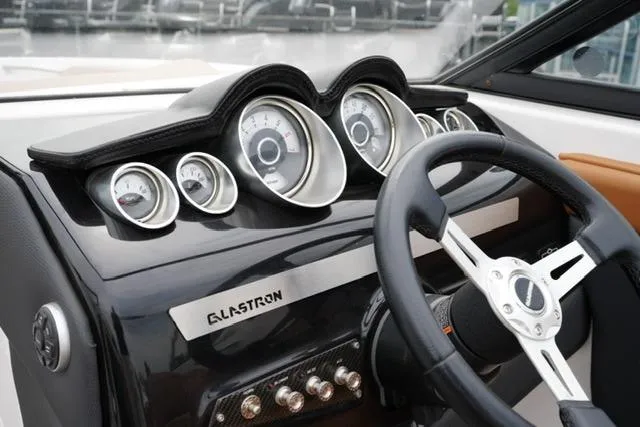 Slide: The Image of Dashboard of a 2017 Glastron GT 245 boat with gauges and steering wheel. - 14