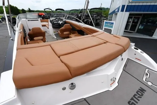 Slide: The Image of 2017 Glastron GT 245 boat with tan seating, docked near a showroom. - 19