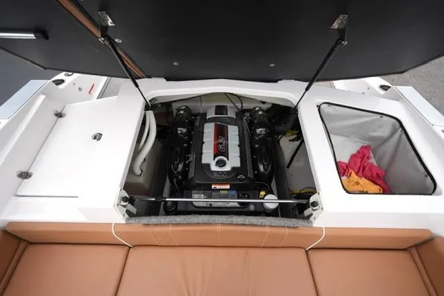 Slide: The Image of 2017 Glastron GT 245 boat engine compartment with open hatch and storage area. - 20