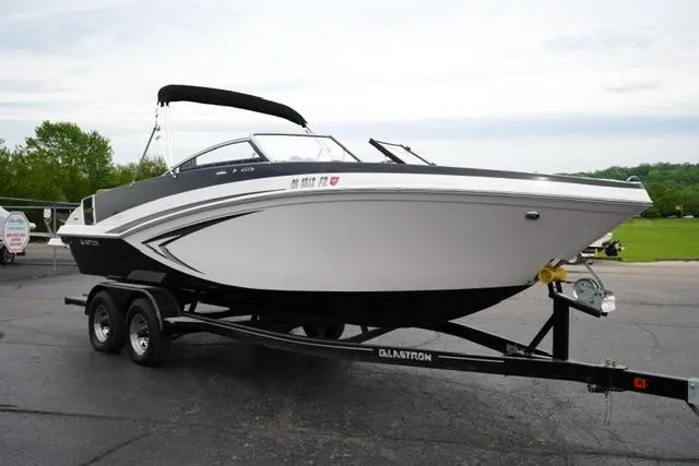 Slide: The Image of 2017 Glastron GT 245 boat on trailer, parked outdoors on paved surface. - 3