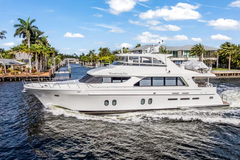 Slide: The Image of 2009 Cheoy Lee 78 yacht cruising on a sunny day, surrounded by waterfront homes. - 1