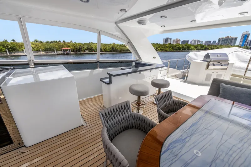 Slide: The Image of Luxurious 2009 Cheoy Lee 78 yacht deck with seating, bar, and scenic waterfront view. - 19