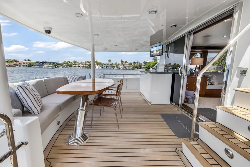 Slide: The Image of Luxurious 2009 Cheoy Lee 78 yacht deck with seating, table, and scenic waterfront view. - 23
